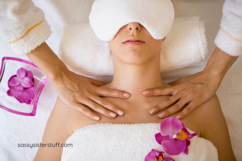 woman with mask over her eyes and flowers laying around her gets a massages to learn the many benefits of regular massage therapy.