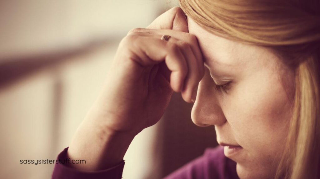 middle aged woman with her hand to her forehead as she deals with guilt.