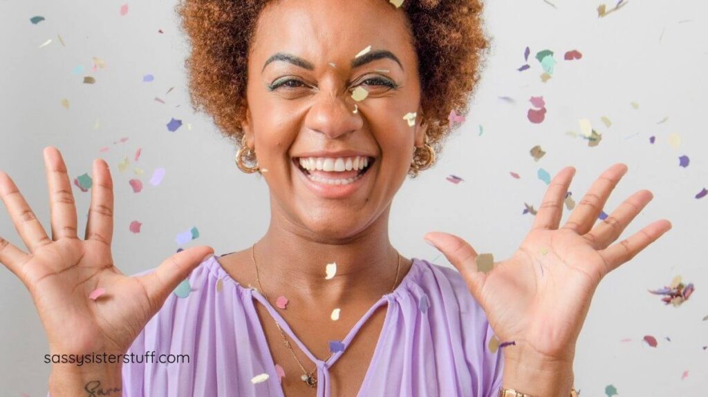 a happy woman celebrating a small win by throwing up confetti.