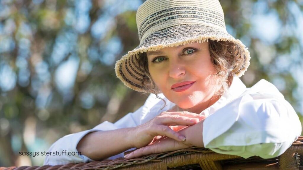 close-up of beautiful and confident middle aged woman with a hat on stares into the camera.