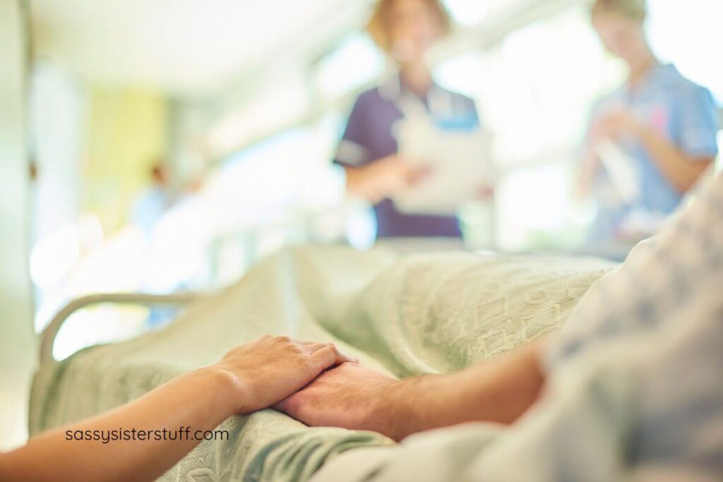 adult daughter holding her elderly mother's hand as she lay in a hospital bed.