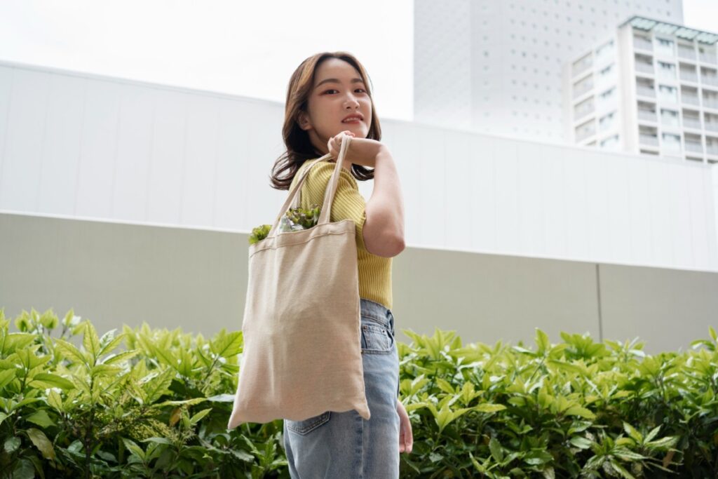 Carrying a faded canvas tote bag