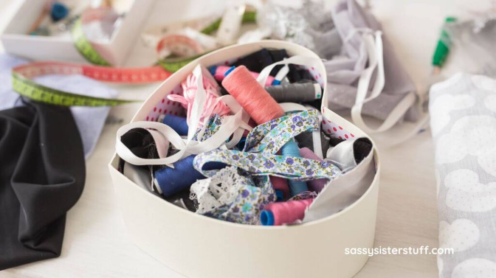 messy heart shaped sewing box that needs to be organized.