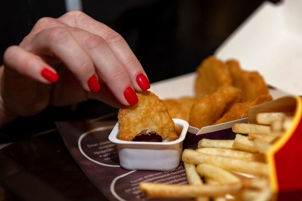 hand dipping mcdonalds nuggets and fries