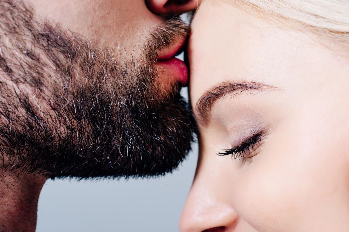 man kissing a womans forehead