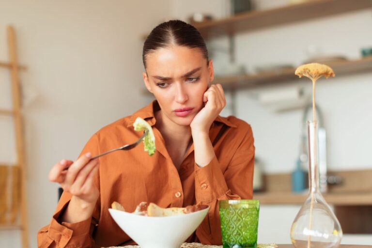 A woman looking at food like it's bad or gross.