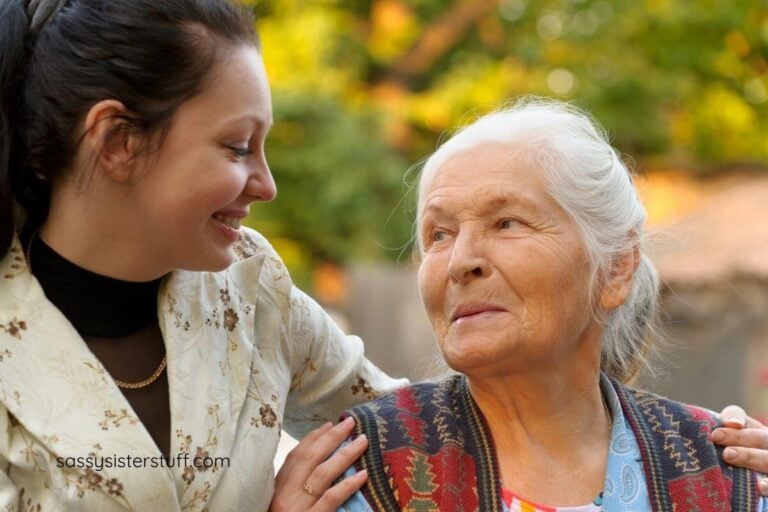 adult daughter and elderly mother smile at each other.