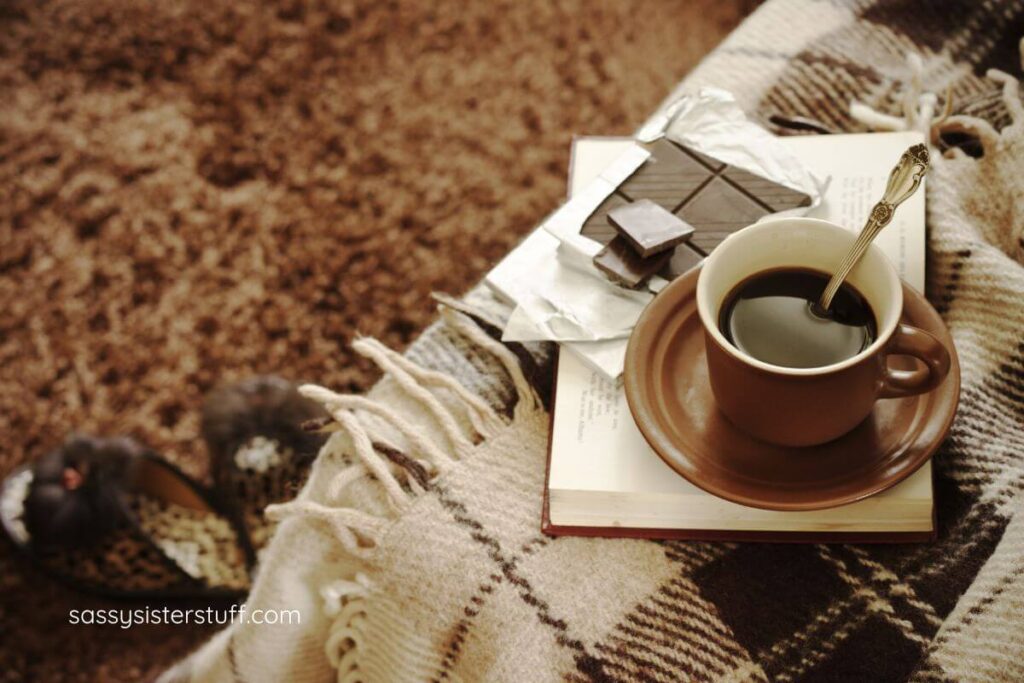 a relaxing space with a blanket, coffer, and chocolate pieces.