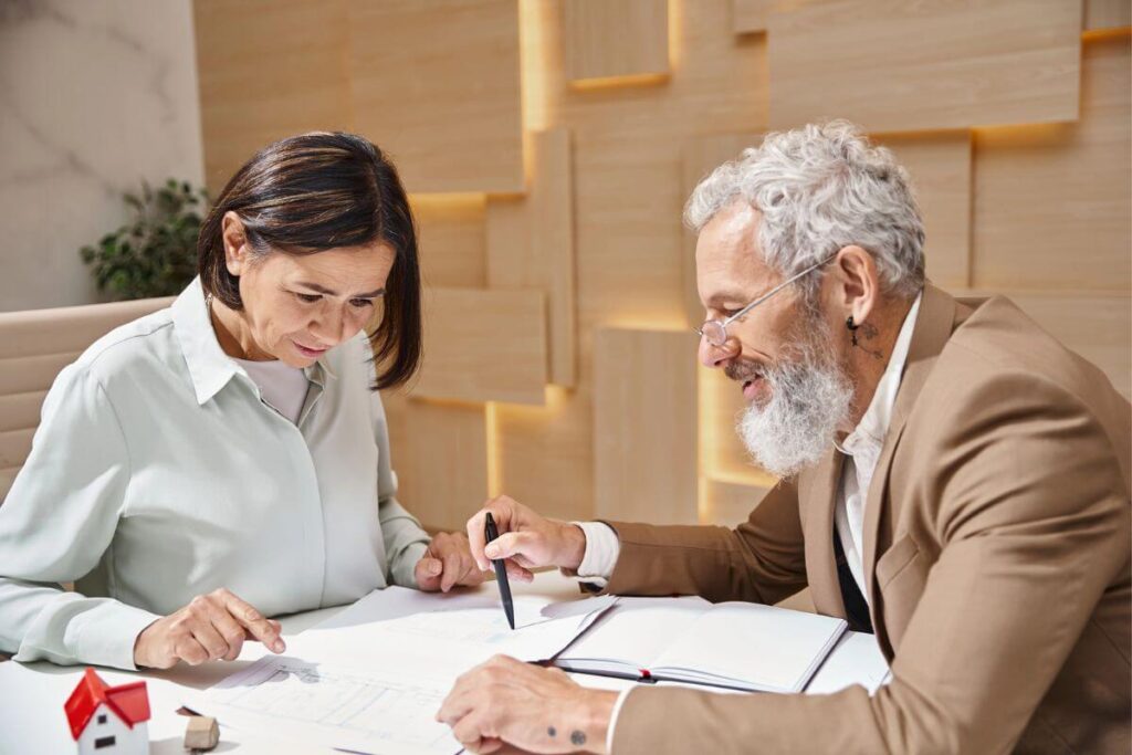 middle aged woman reviews paperwork with a financial advisor to prepare for responsible homeownership.