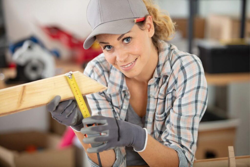 happy middle aged woman in work clothes as she does reonnovations on her home.
