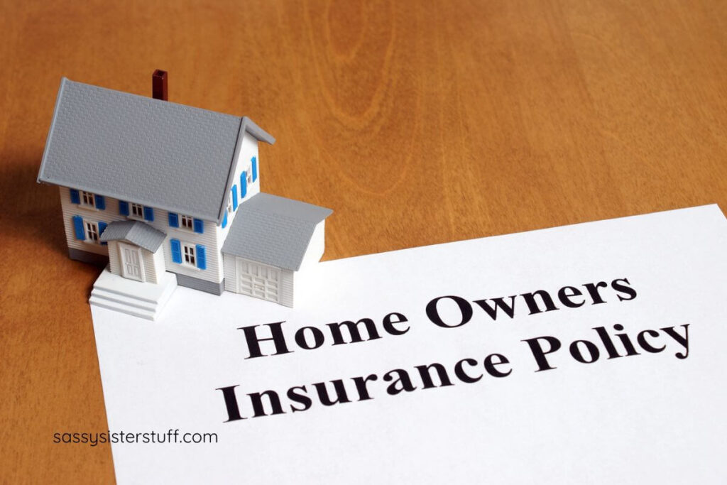 flat lay home owners insurance policy with small house sitting on the corner.
