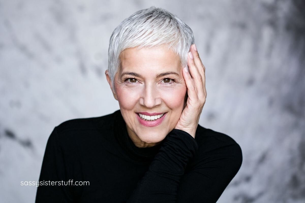 mature woman with short silver hair dressed in dark sweater.