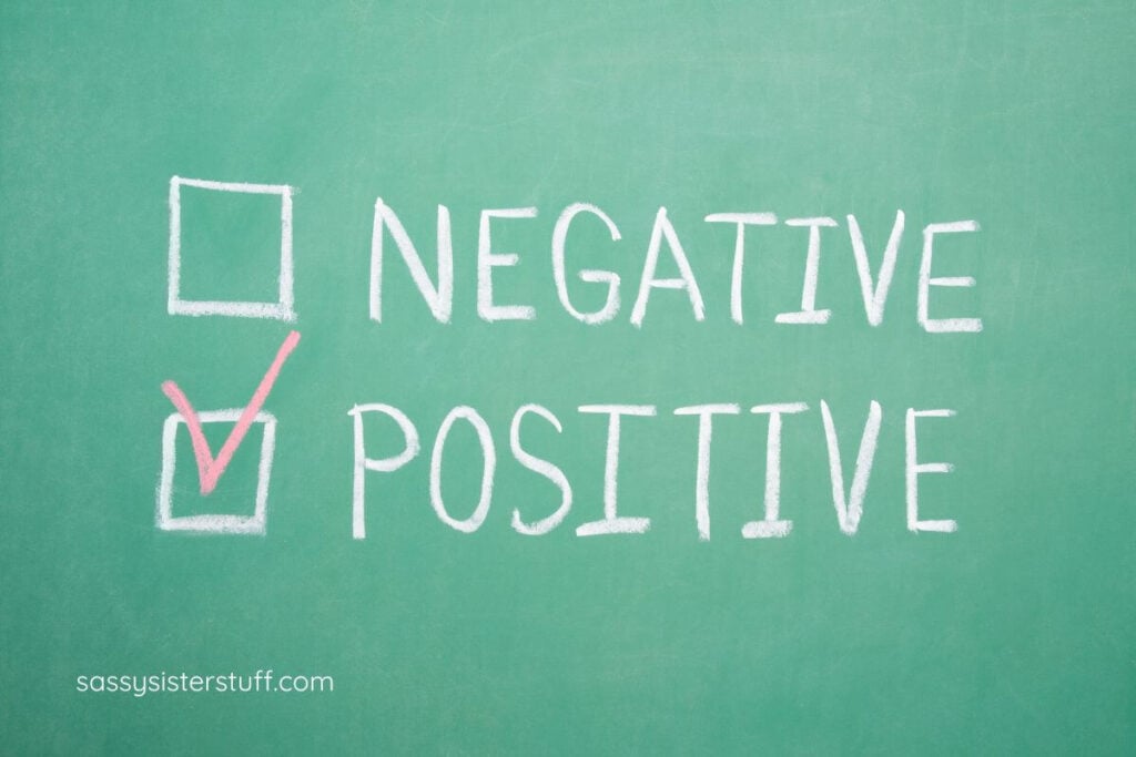 Negative and Positive written on a green chalkboard with a check mark next to Positive.