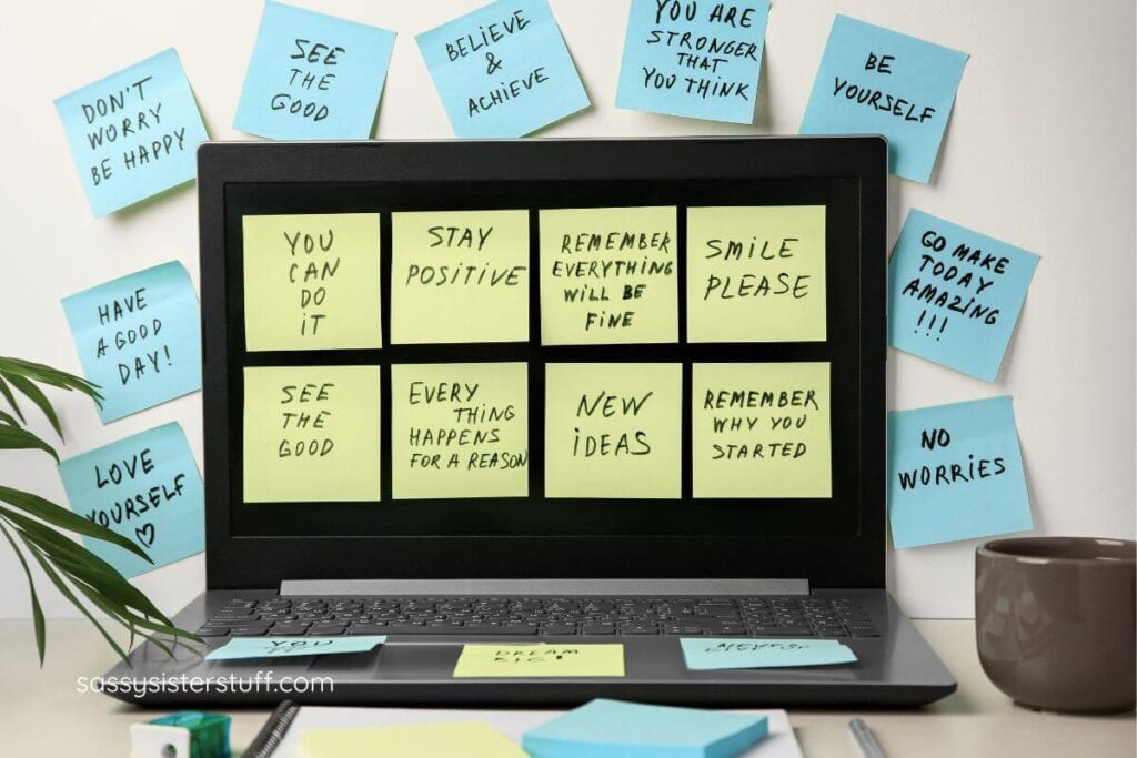 affirmations written on sticky notes and posted on a computer screen and the wall.