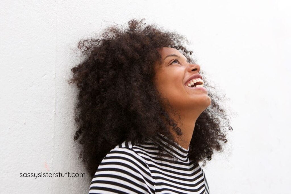 happy middle aged woman smiling up into the sky thinking about positive affirmations.