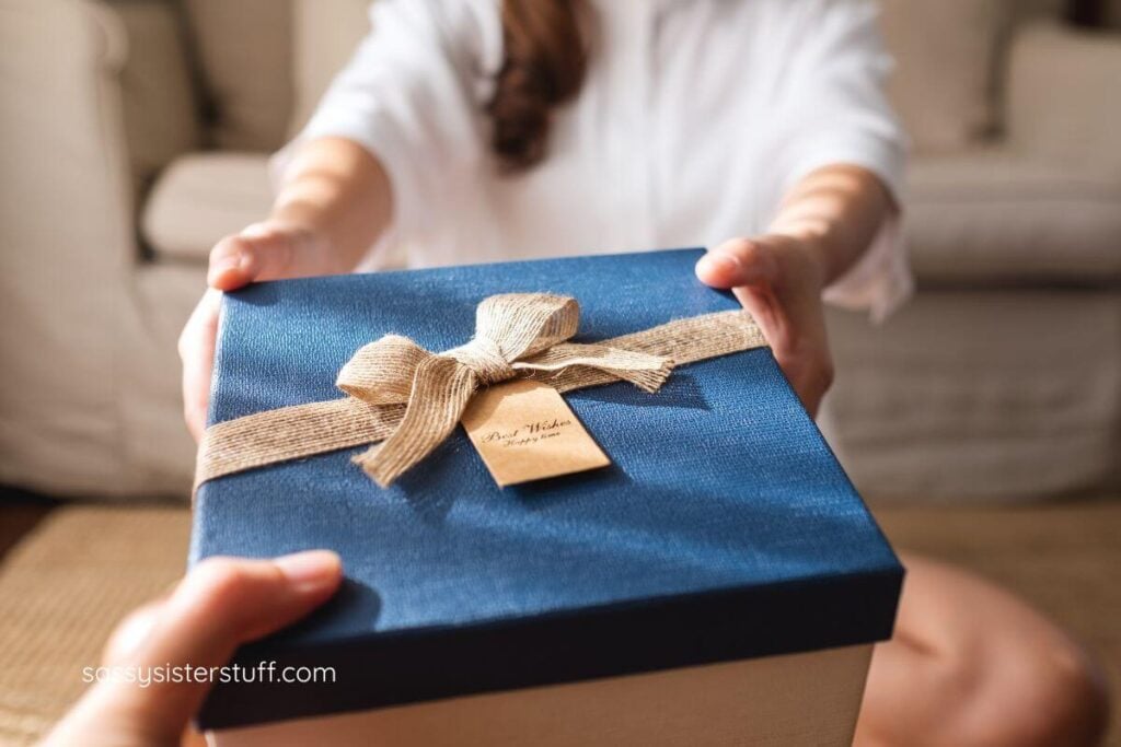 a female handing a lovely gift box to a friend.