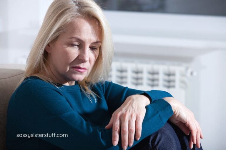 sad middle aged woman sitting on the floor thinking about her adult child going no-contact.