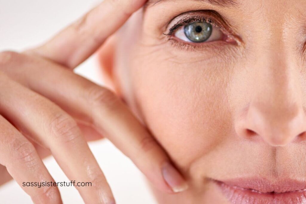 close-up of half a face of a beautiful woman with her fingers up to her face.
