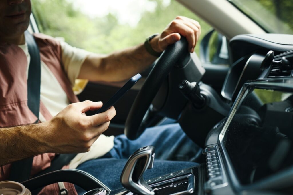 Secretly checking their phone under the dash