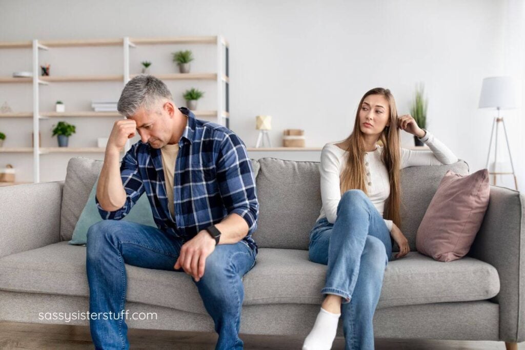 husband and wife having an argument sitting on a sofa.