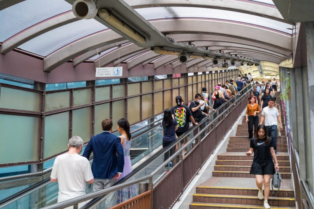 Staring blankly ahead while congestion builds, causing a traffic jam.