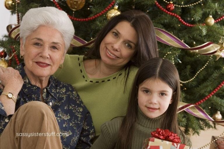 three generations of females sitting in front of their Christmas tree.