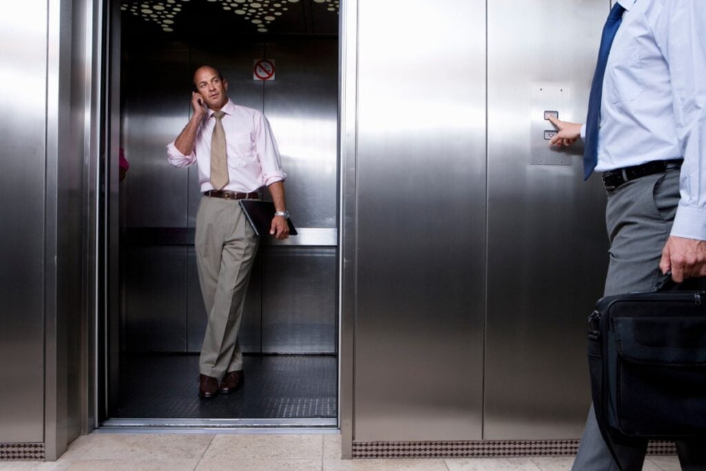 The elevator stops and both people pretend not to notice each other.