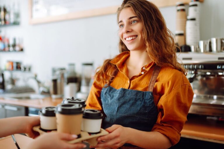 woman barista handing a tray to a customer