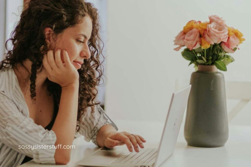 woman reading one her laptop about how to feel more independent and capable at home so she can take care of her new home.