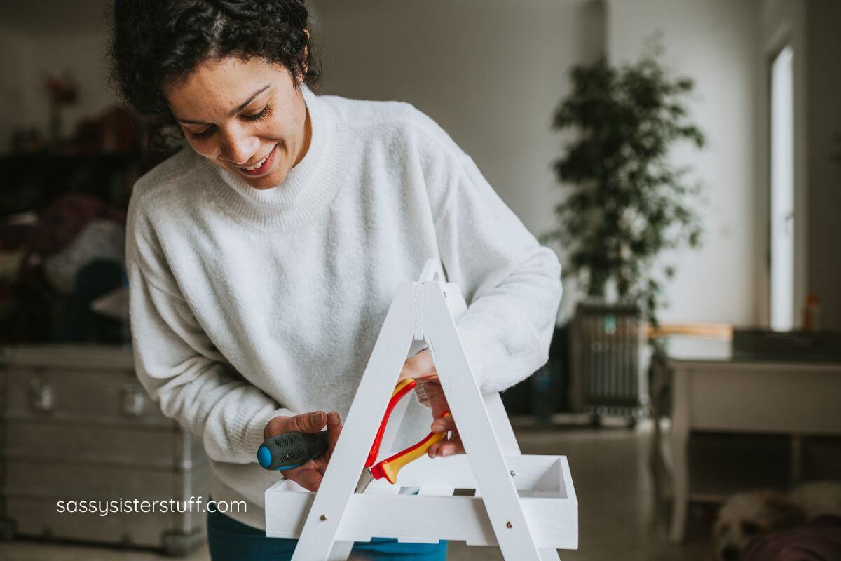 woman using tools to make a wooden plant holder.