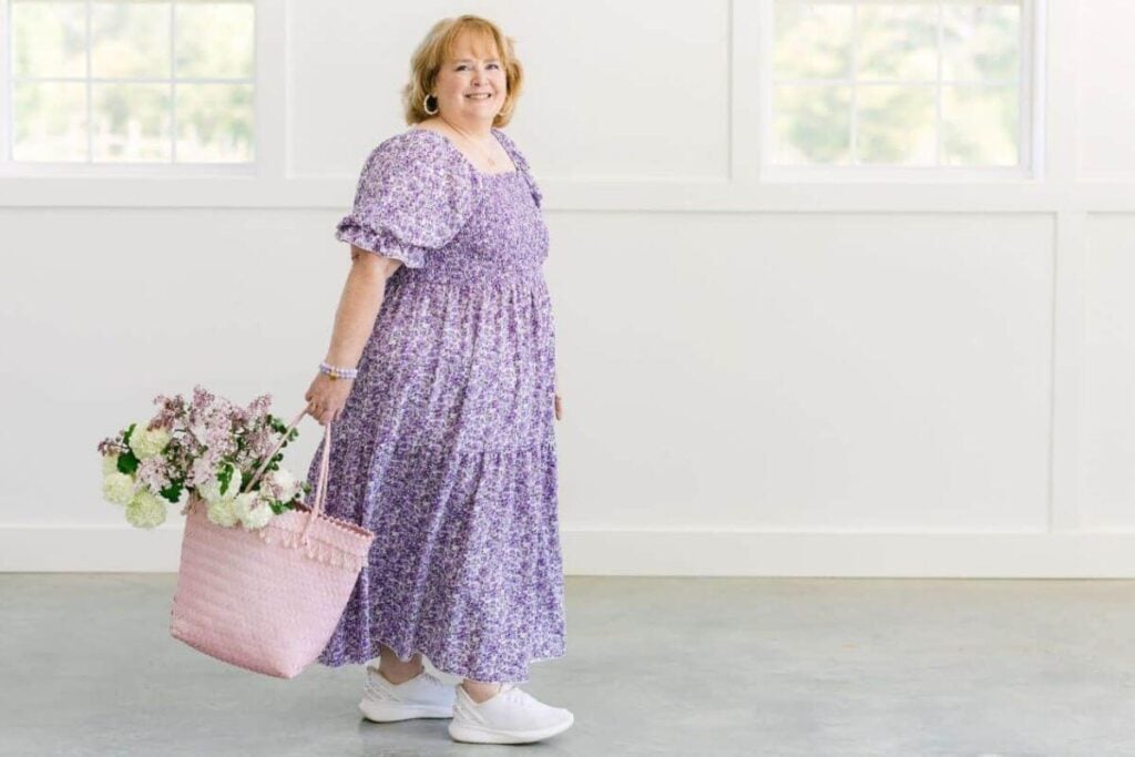 Founder of Sassy Sister Stuff models a comfortable, sassy, and fun floral dress in shades of lavender.