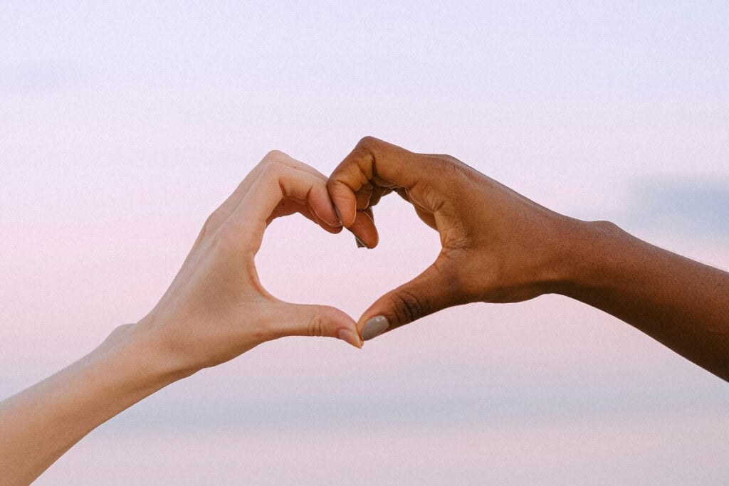 two people make a heart with their hands.