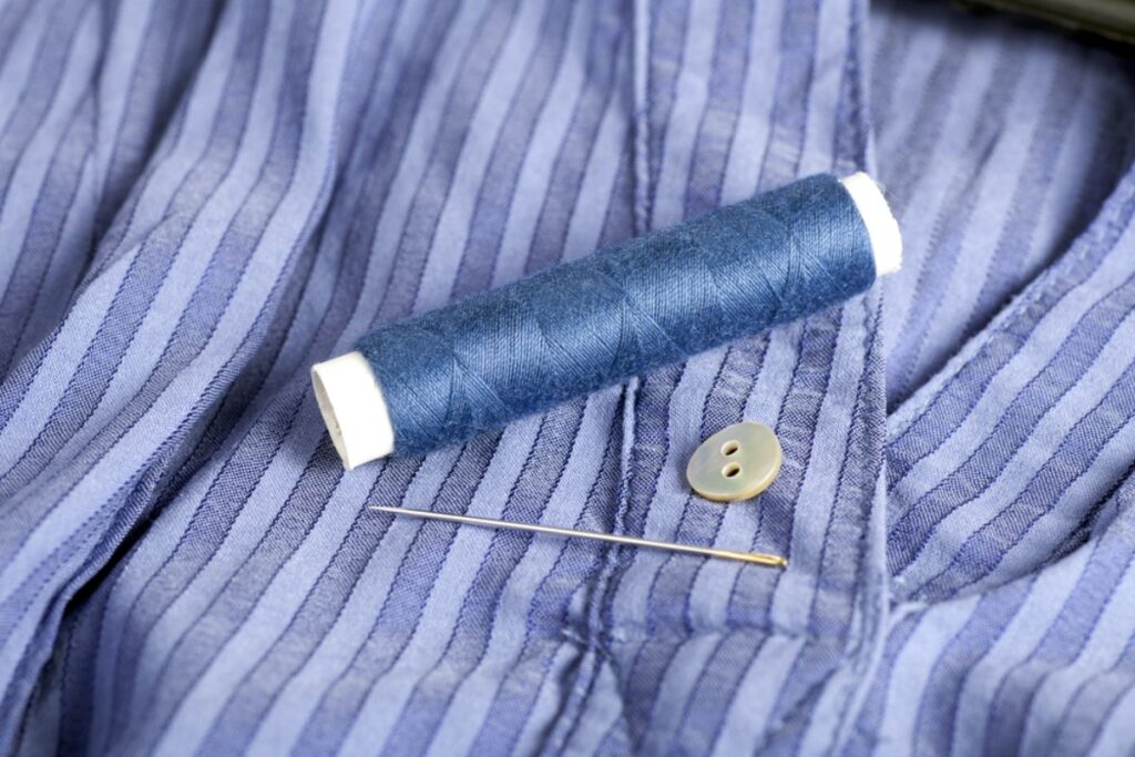 Mending clothes with needle and thread