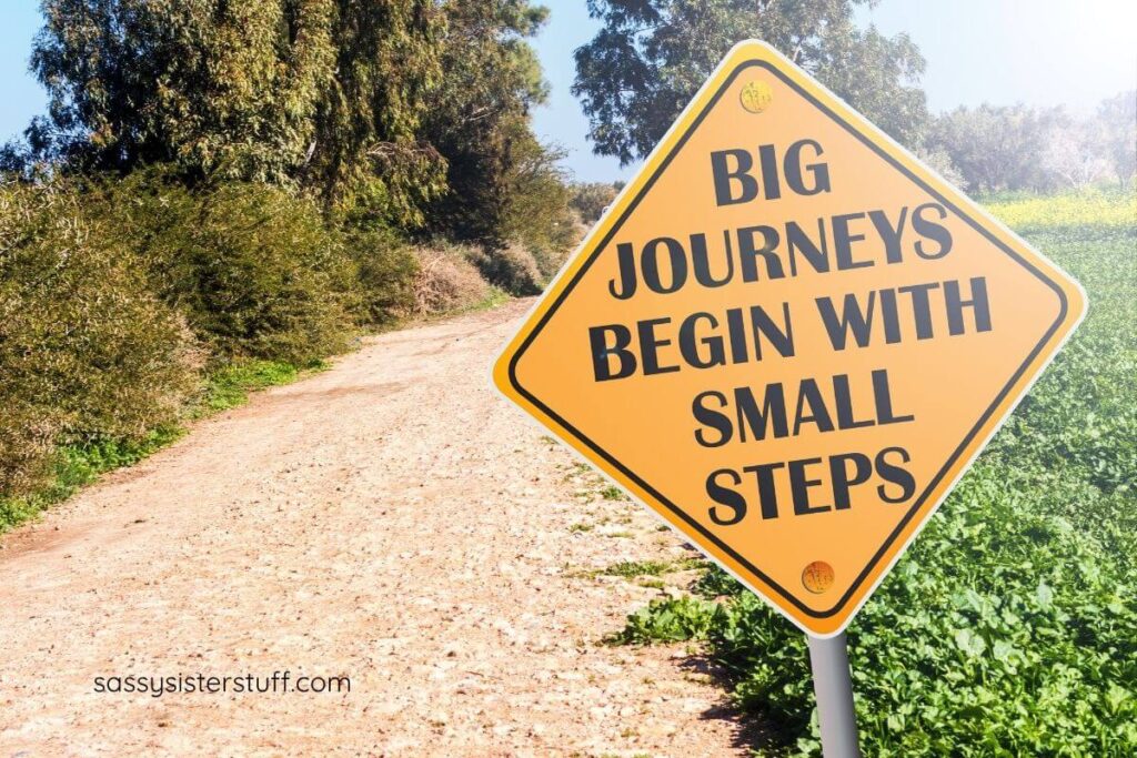 dirt road with a yellow sign that says BIG JOURNEYS BEGIN WITH SMALL STEPS.