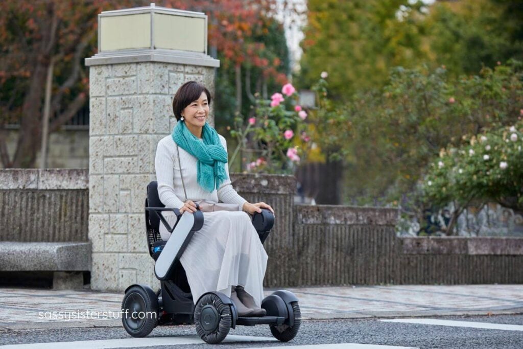 Asian woman in an electric scooter crossing the street.