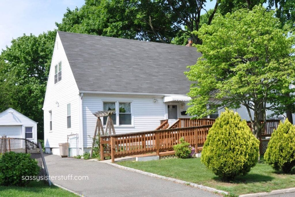 a white suburban home with a handicap ramp built on the outside for making your elderly parents' space accessible.