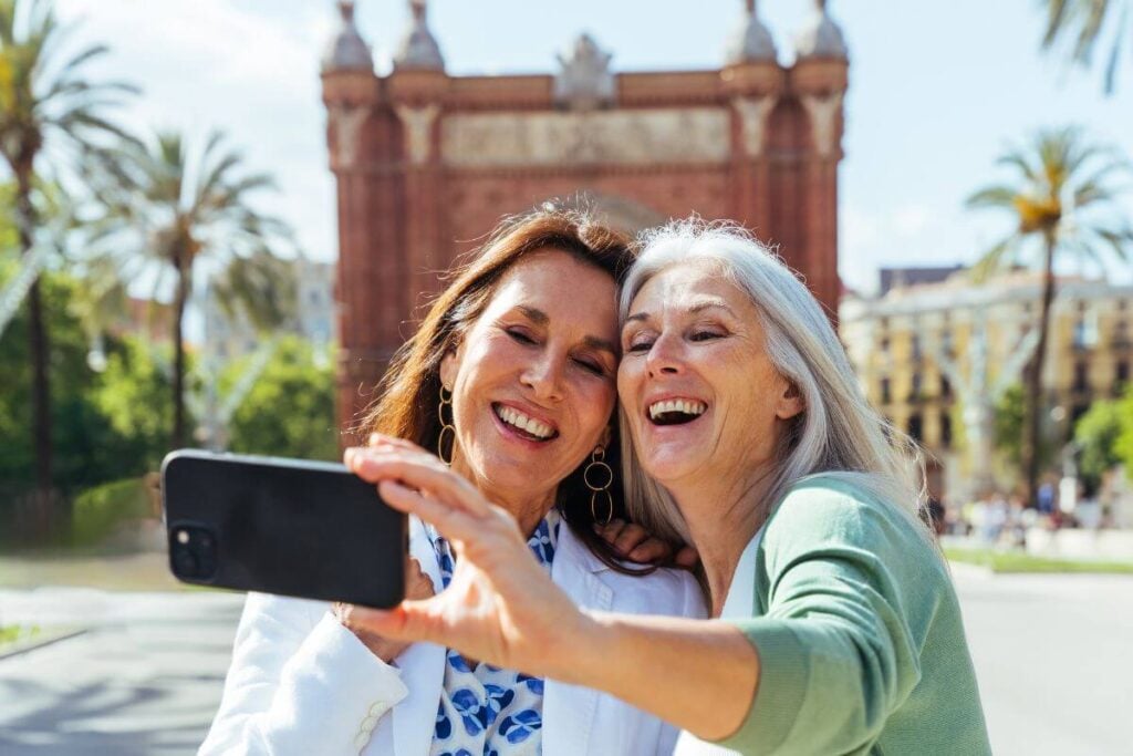two middle aged women snapping a selfie while traveling.