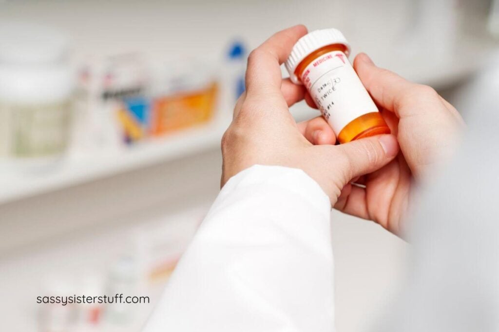 a close-up of a pharmacist's hands holding a bottle of medicine.