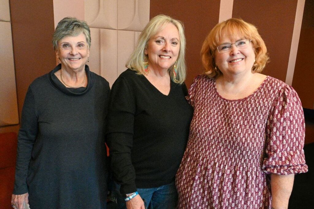 three middle aged women pose for a picture from a girls' weekend getaway.