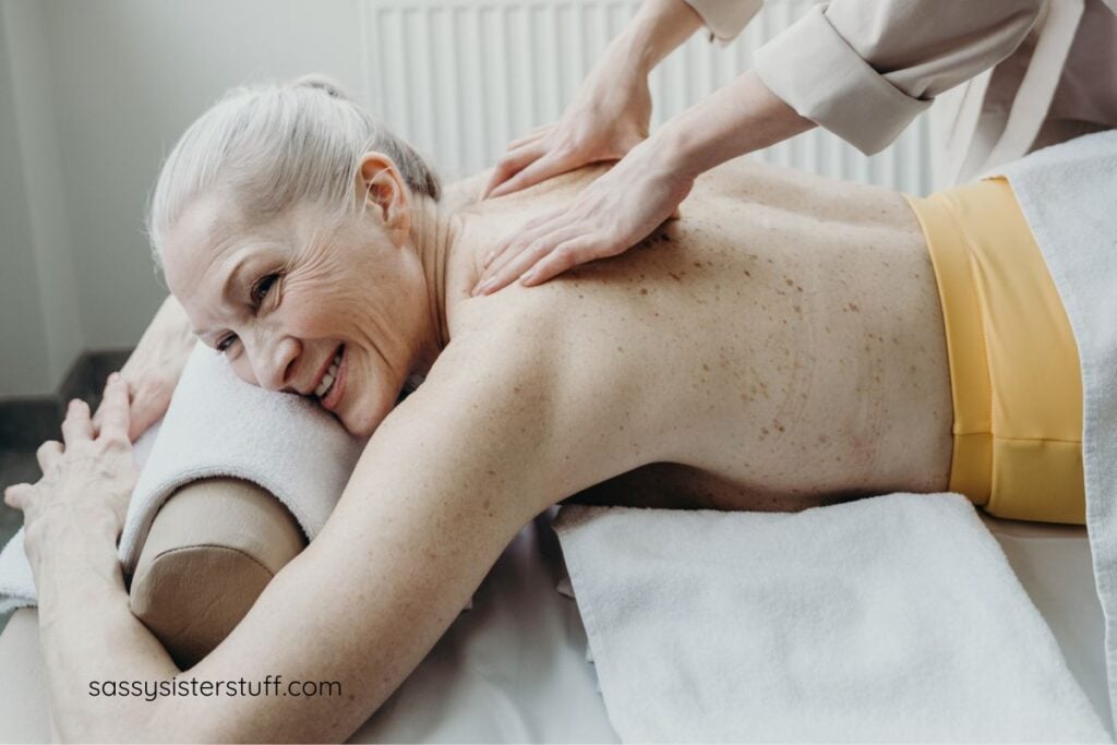 midlife woman smiles while she gets a massage.