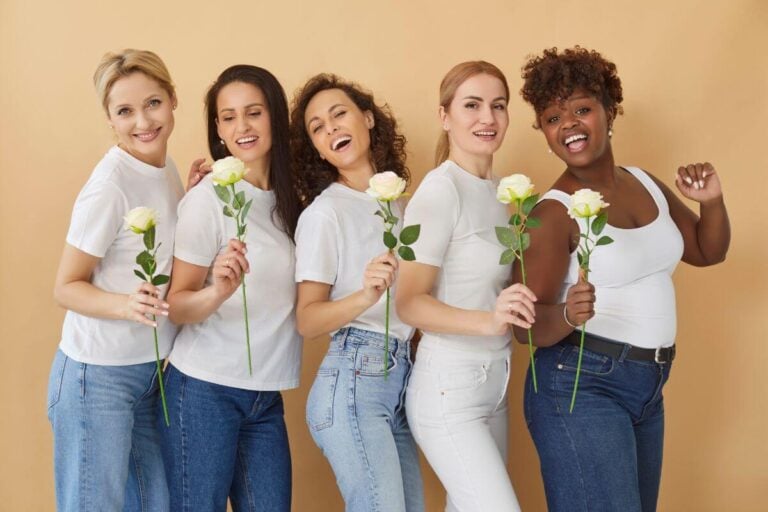 diverse group of midlife women with each holding a yellow rose.