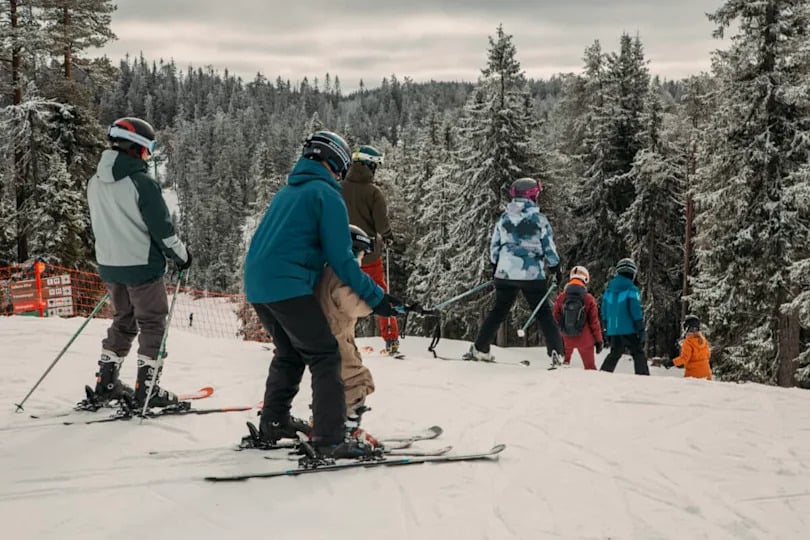 people at the top of a mountain ready to sky down.