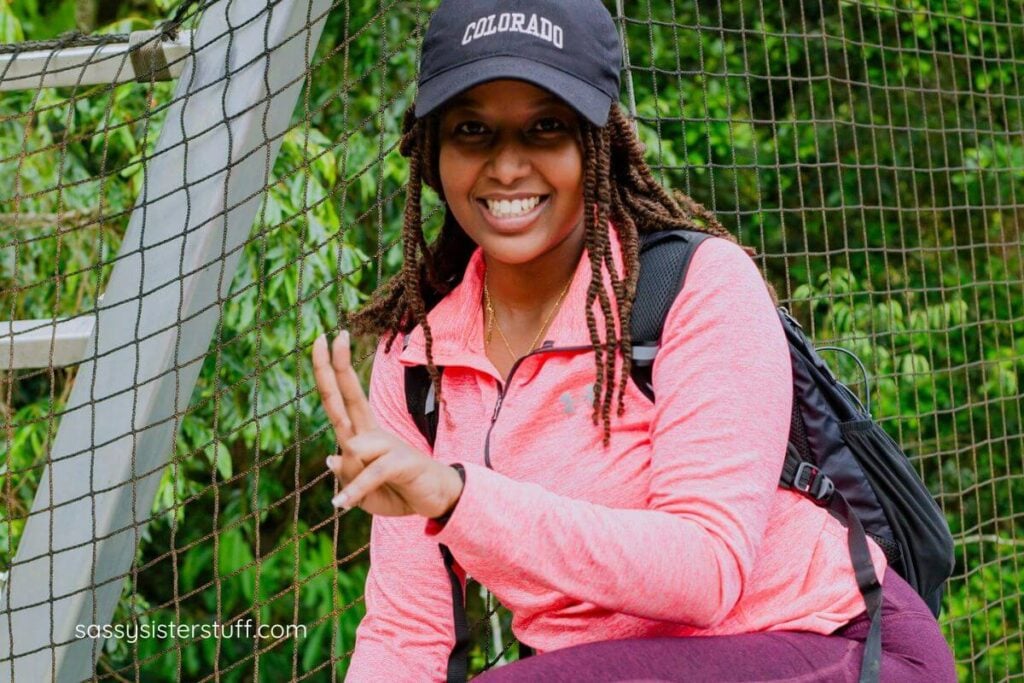 an excited midlife woman crossing a high suspension bridge.