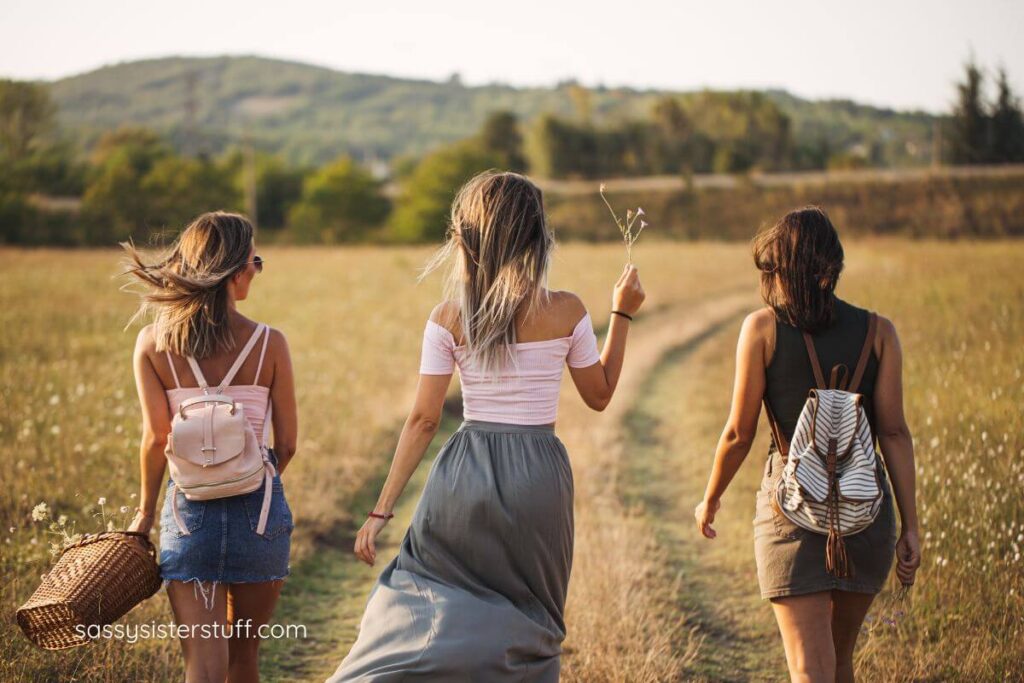 three females walk through a grain field on a midlife adventure.