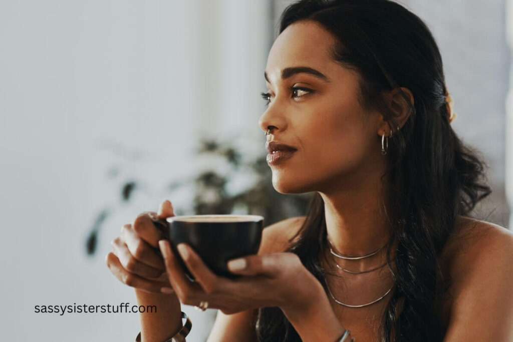 pretty light skinned African American woman sips on tea and relaxes.