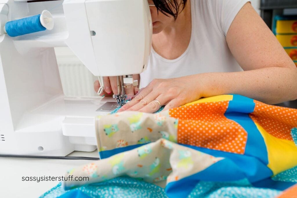 a woman using her sewing machine to quilt.
