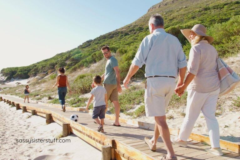 multigenerational family walking on a boardwalk at the beach.