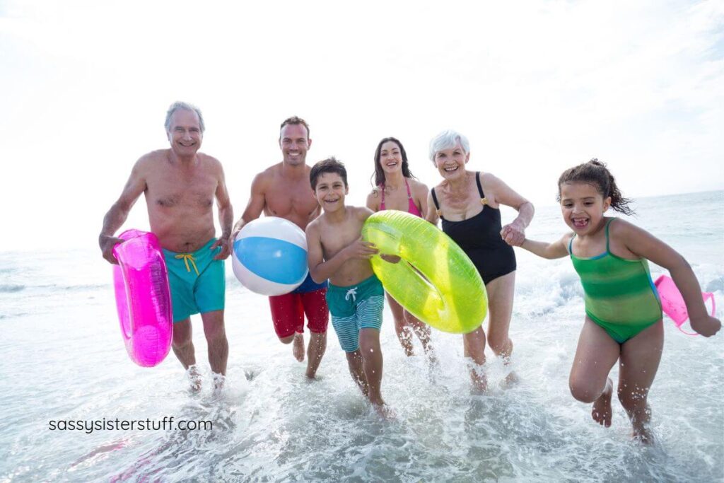 multigenerational family running in the waves on the shoreline