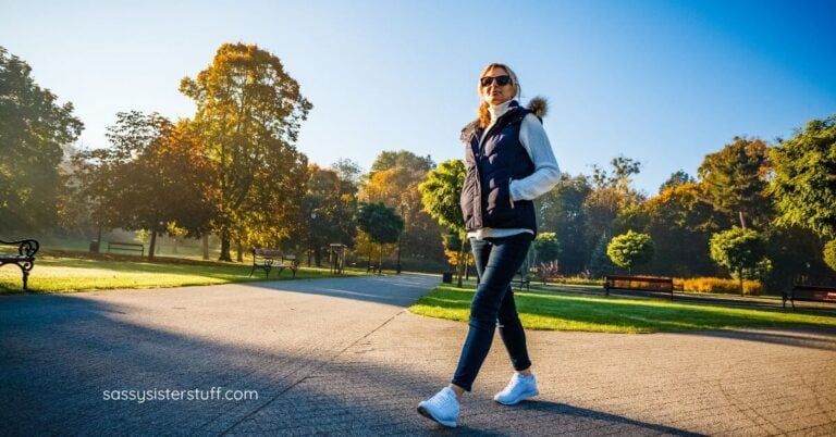 midlife woman walking through a park.