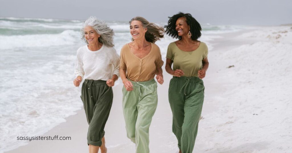 three midlife women walking on a beach.